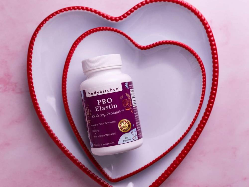 Bottle of Body Kitchen Pro-Elastin resting in a heart-shaped dish