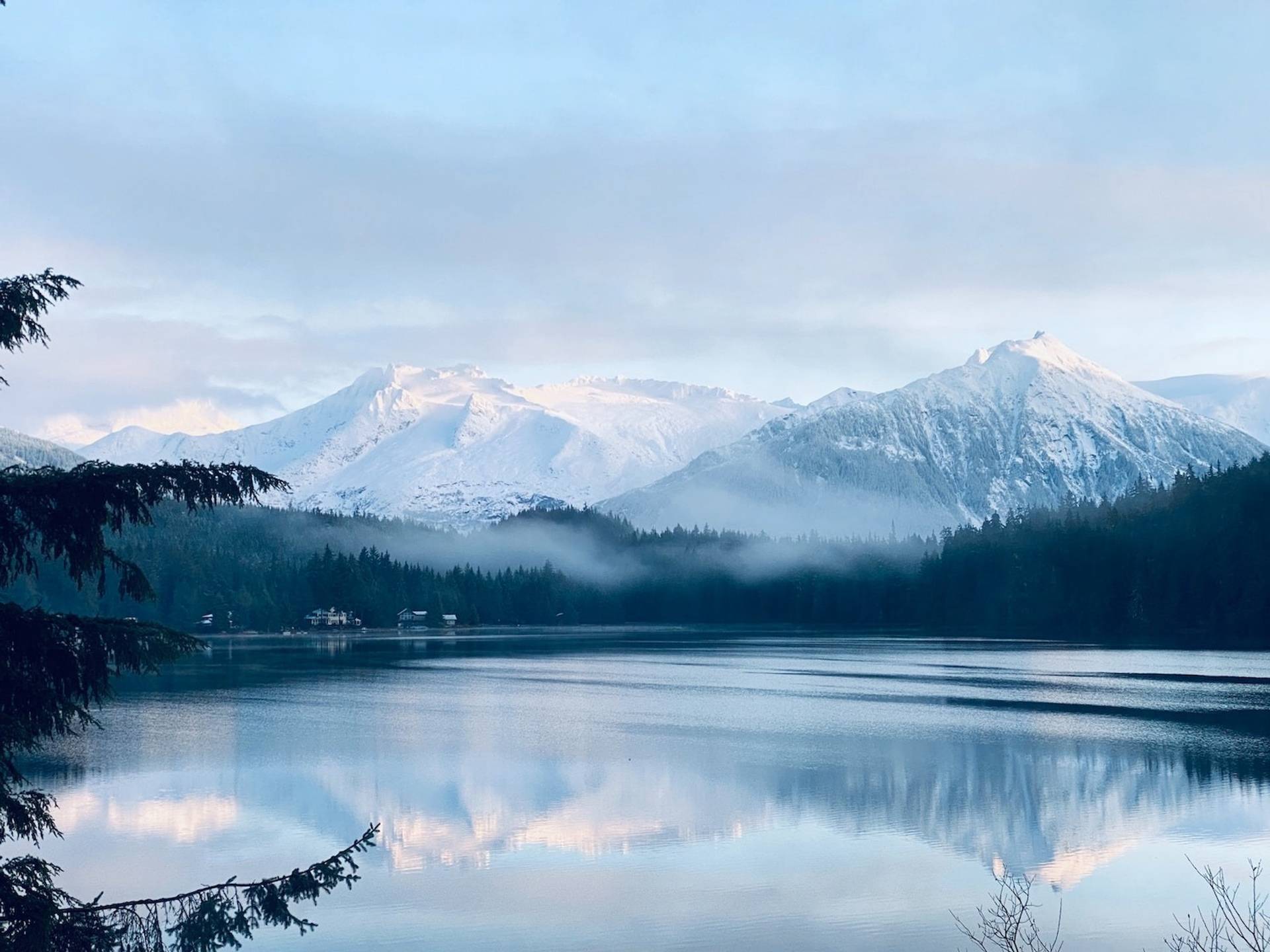 Snowy mountains and glassy lake to represent where to buy e-bikes in Alaska