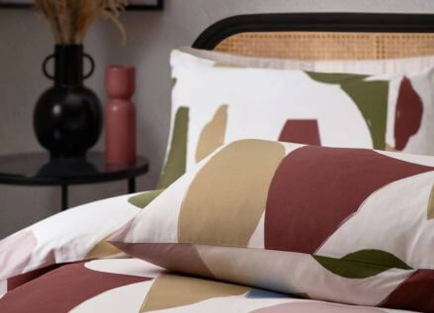 A HÖEM duvet cover set with a multicoloured abstract design, featuring a multitude of printed shapes in various tones.