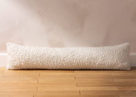 white boucle draught excluder sitting on a wooden floor