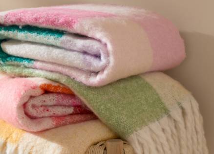 Throws folder up with a large check design in pink green and yellow