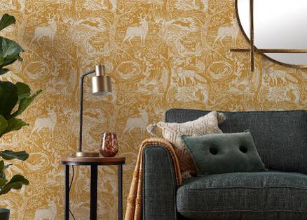 yellow winter woods wallpaper in a living room setup with a sofa and lamp