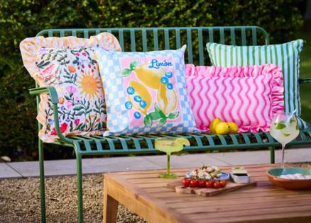 Outdoor cushions with blue and green stripes, pink squiggles and fruit designs
