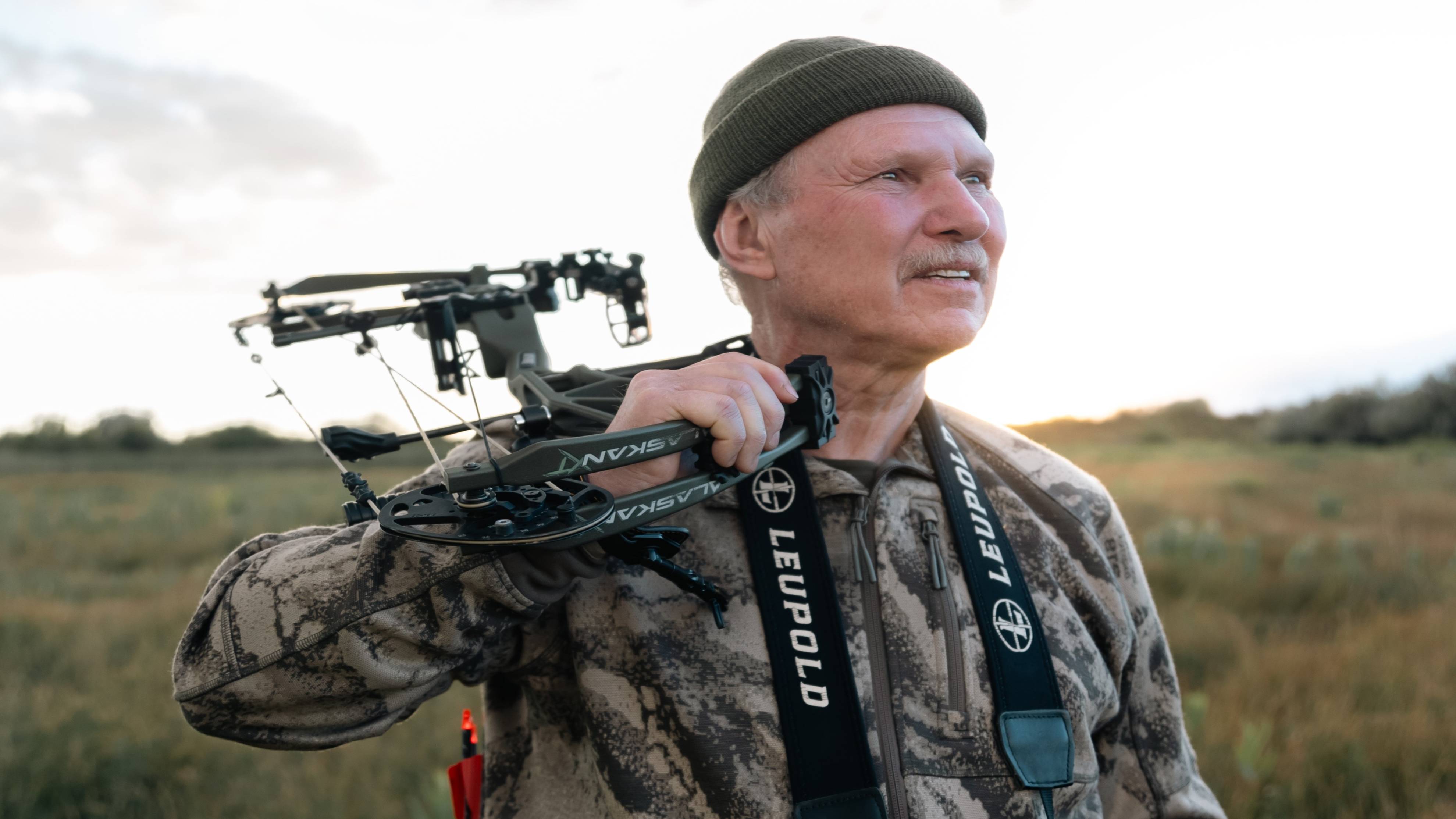 Chuck Adams with Bear Archery Alaskan XT RTH compound bow standing in a field.
