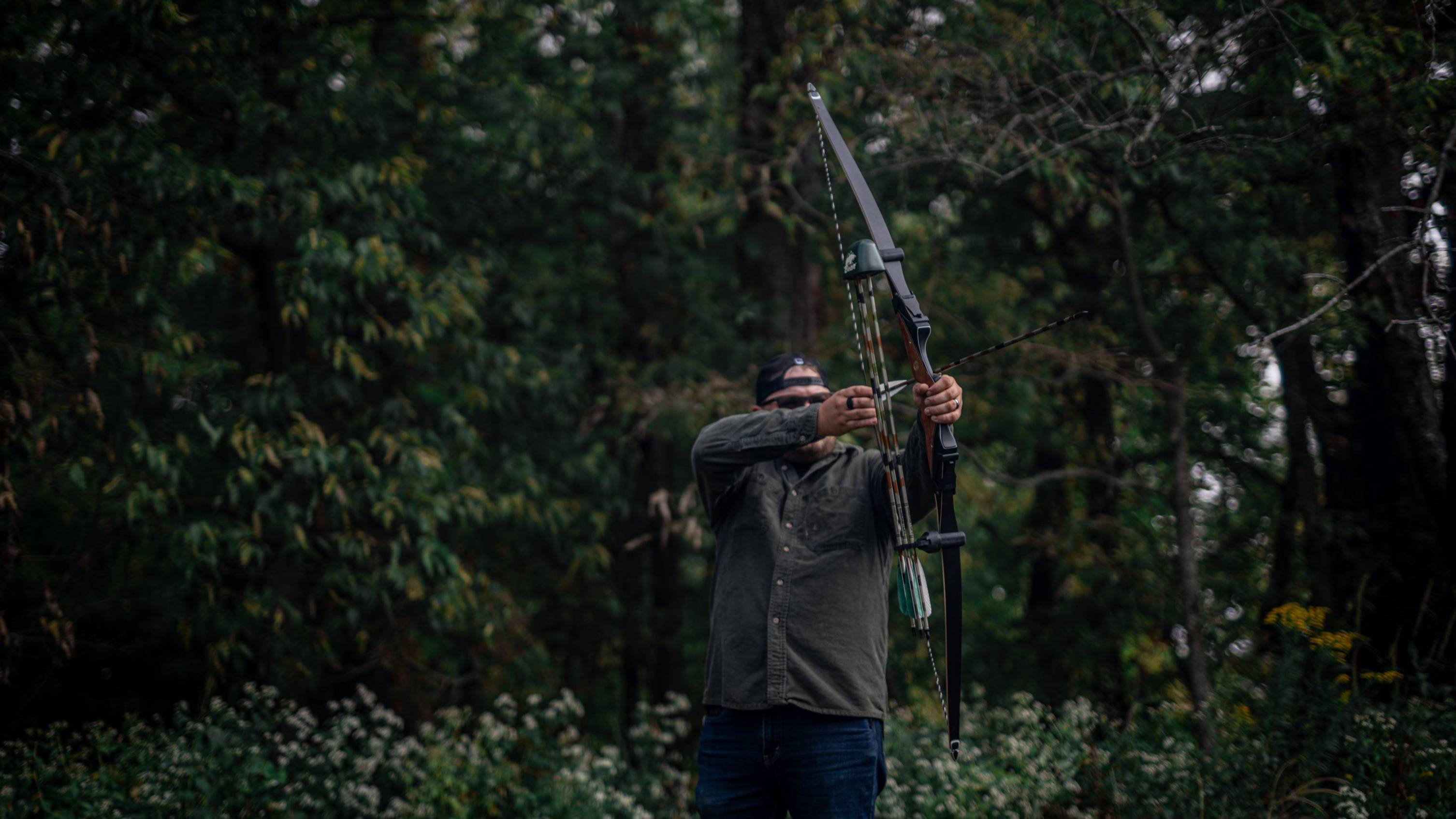 Man about to shoot an arrow with Bear Archery Take Down Longbow Limbs