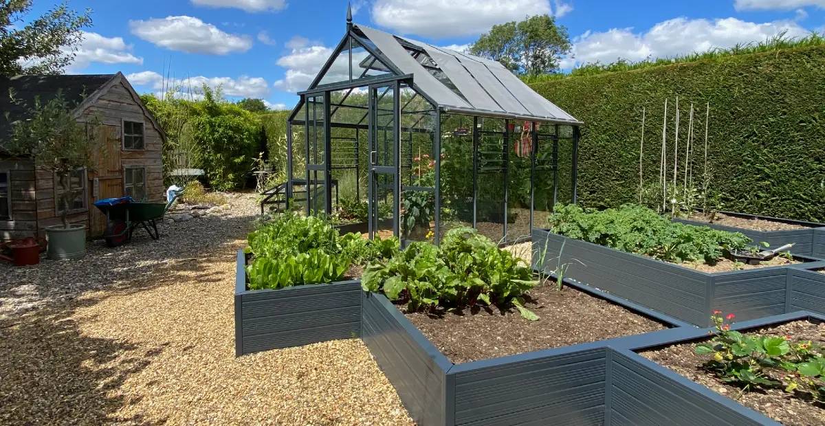 Landscaped garden with raised beds and a greenhouse