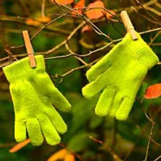 two green gloves pegged up to dry