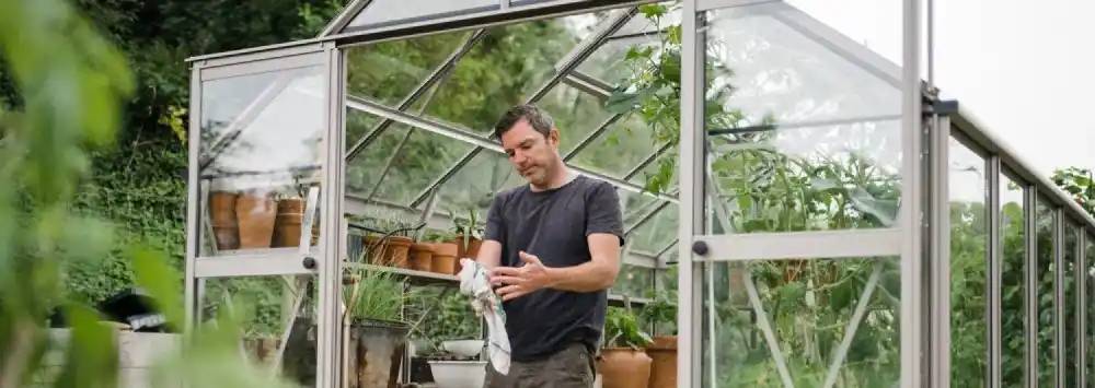 Man wiping his hands in his greenhouse