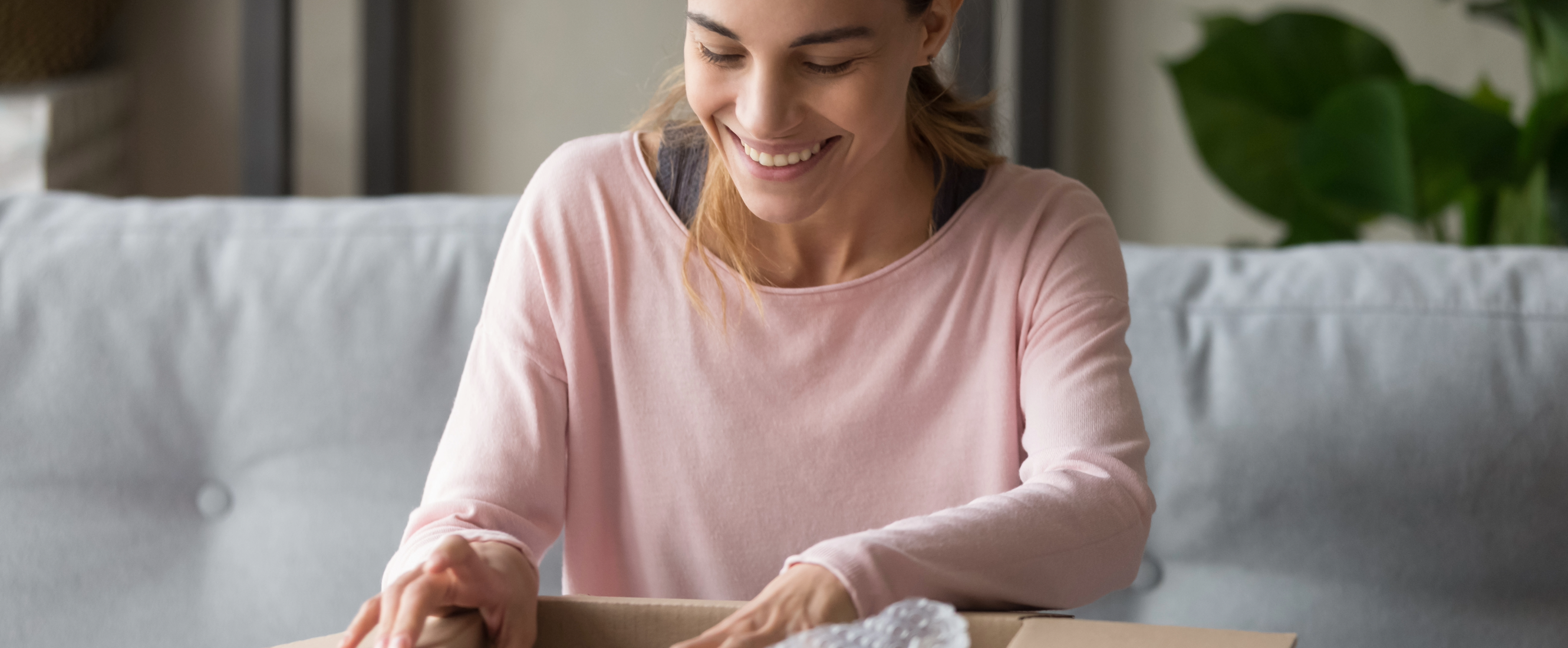 Woman in pink shirt unboxing a gift