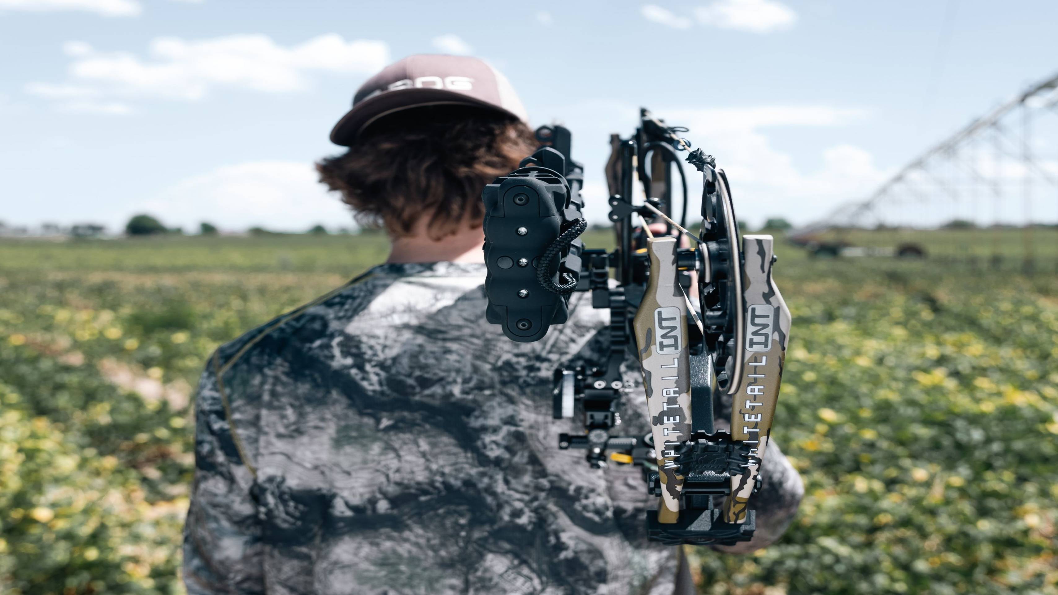 Man holding a Bear Whitetail INT compound bow from Bear Archery over his shoulder.