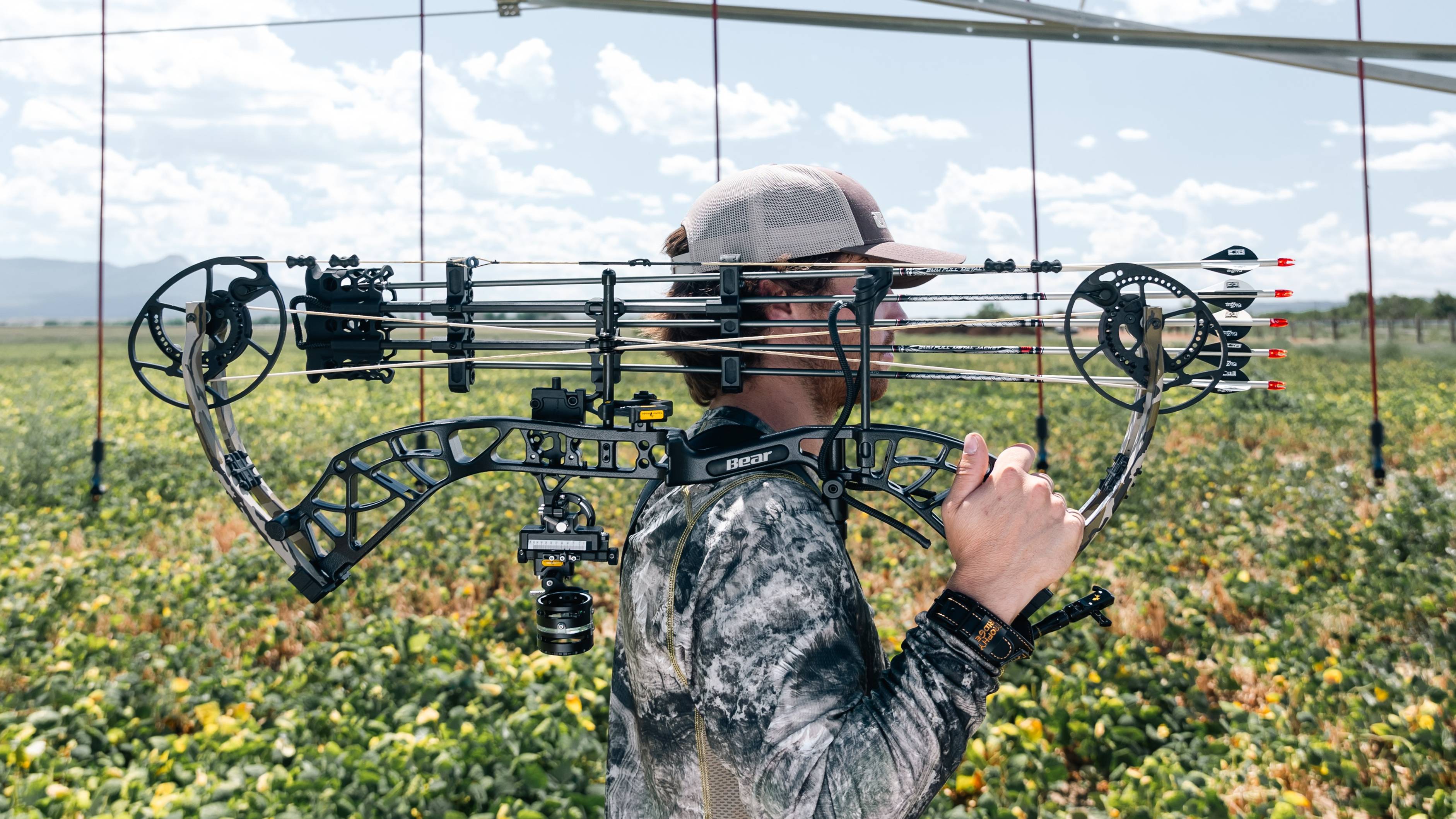 Man holding Bear Whitetail INT RTH compound bow in the middle of a field.