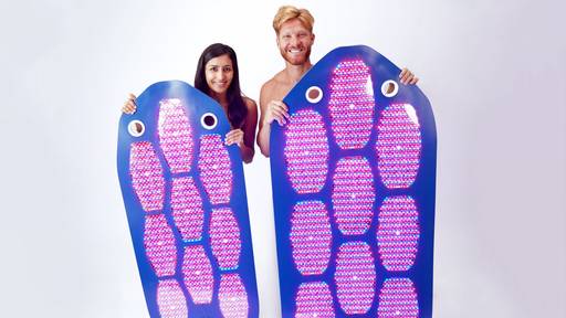 Man and women standing next to the Celluma DELUX and DELUX XL for comparison.