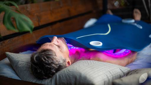 Man laying on back outside getting a red light therapy treatment with the Celluma DELUX XL.
