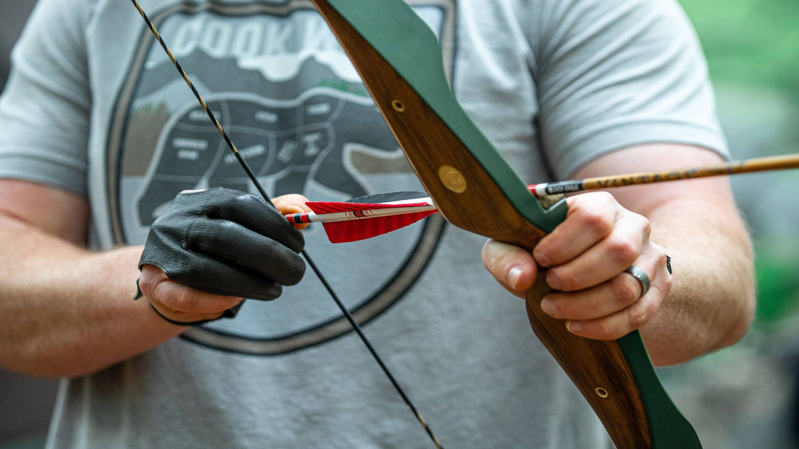 Nocking a Green Glass Grizzly recurve bow from Bear Archery