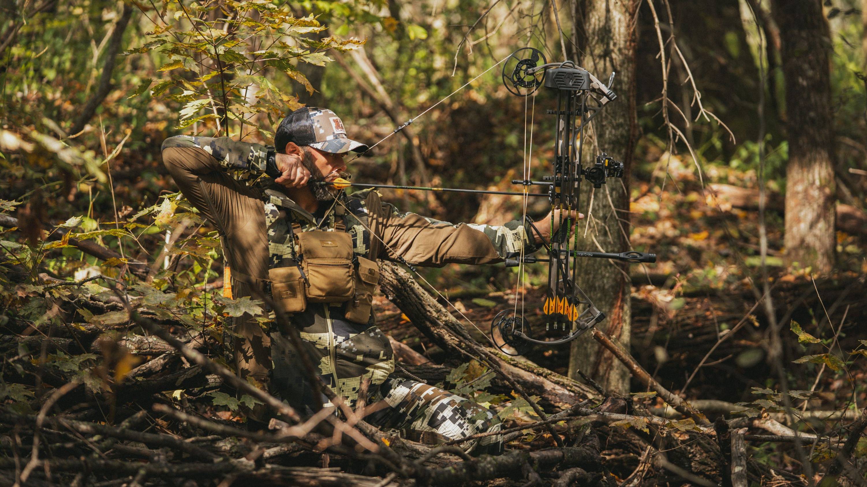 Man in the woods shooting the Bear Alaskan Pro compound bow from Bear Archery.
