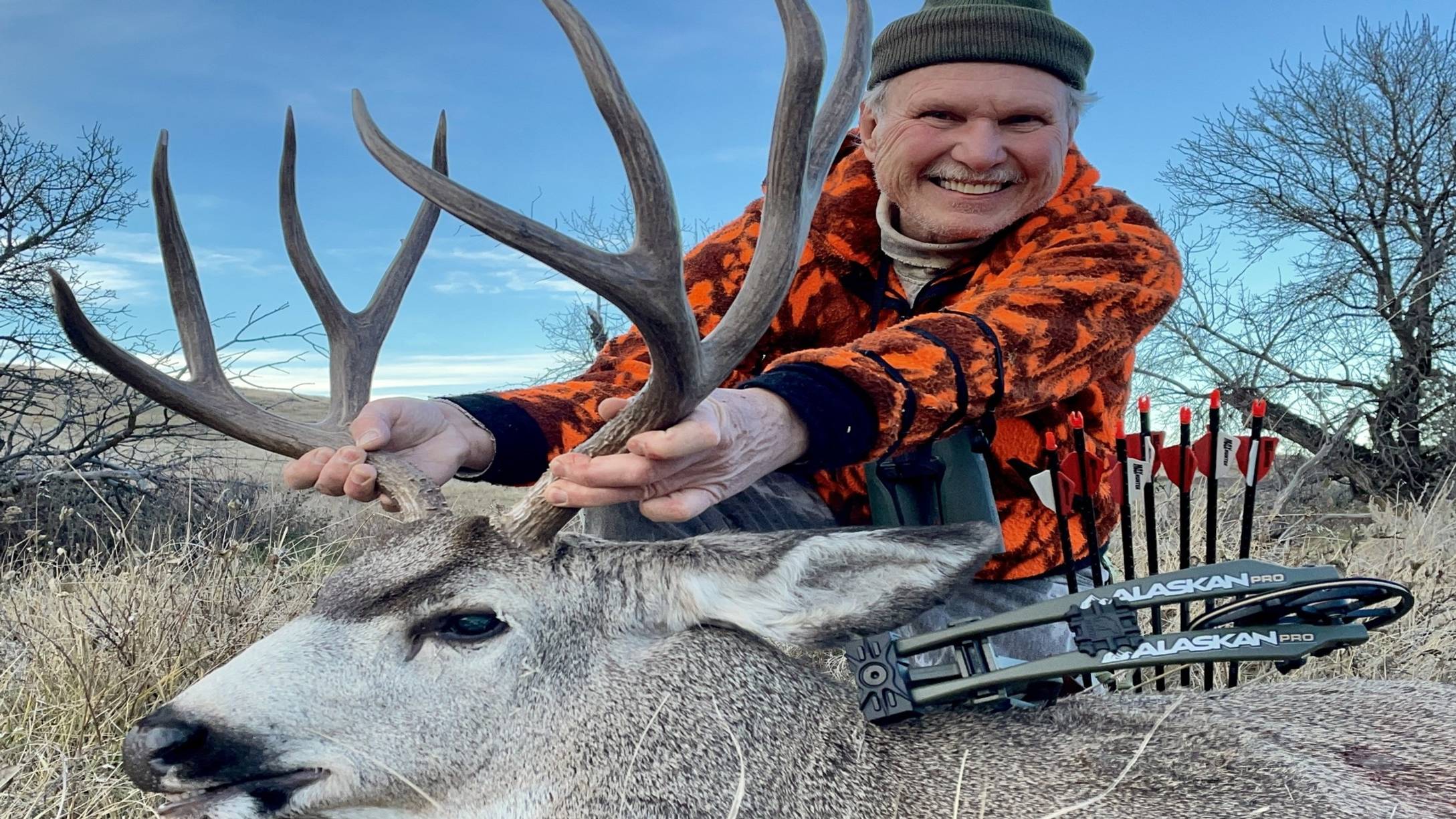 Chuck Adams with a Bear Archery Alaskan Pro RTH compound bow and a mule deer.