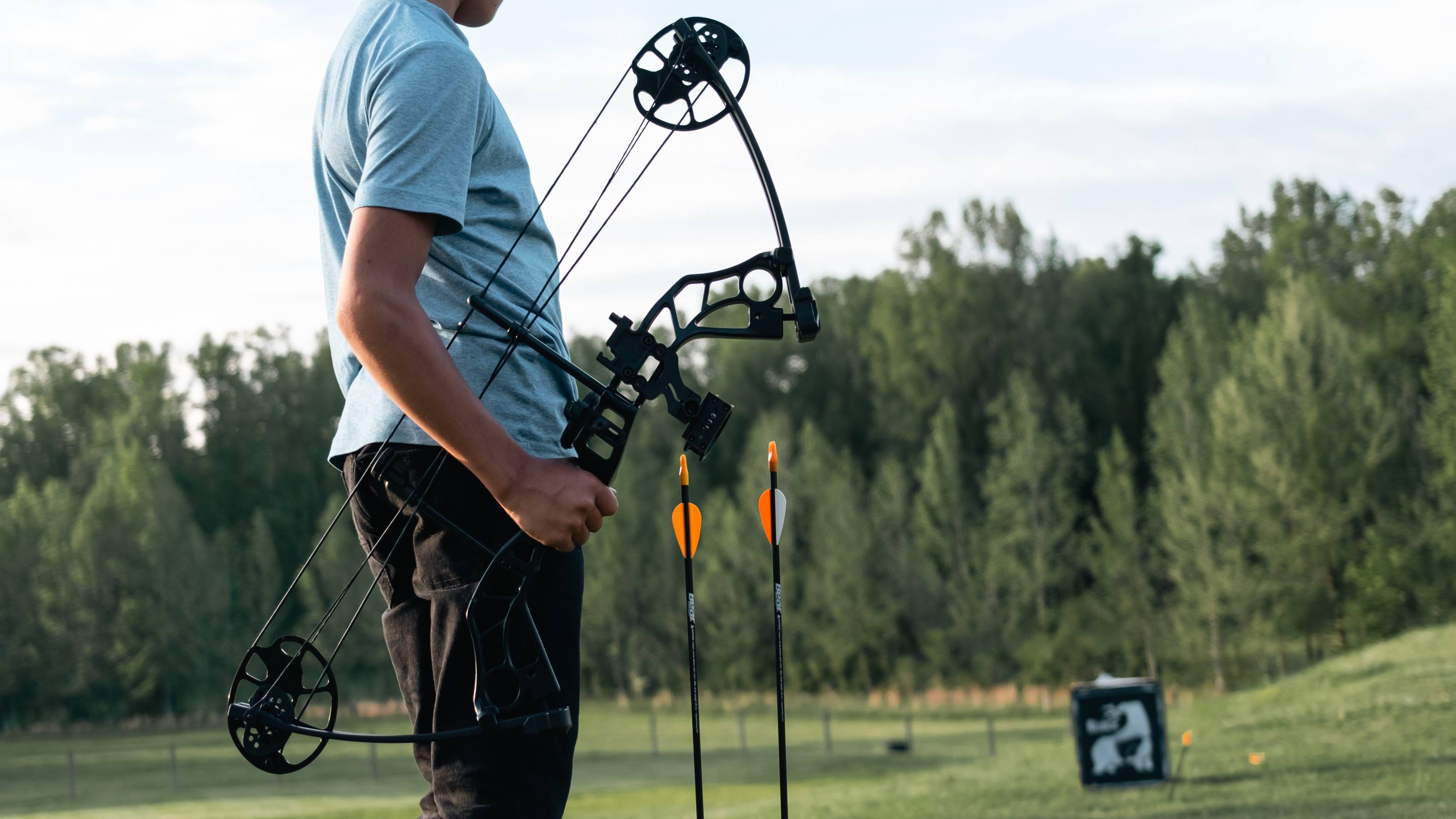 Kid holding the Shootout youth bow from Bear Archery while looking at a target.