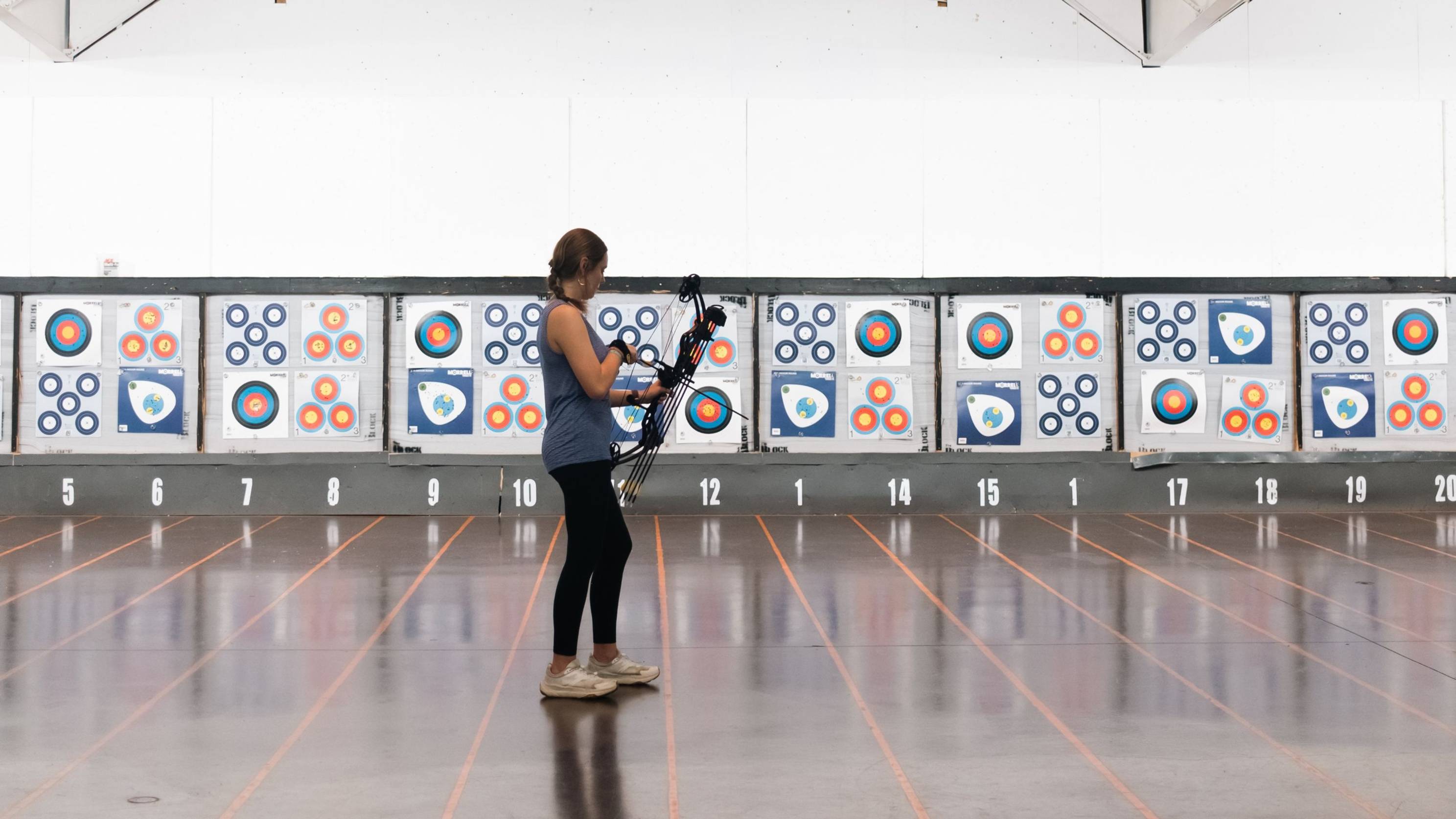 Image of girl preparing to shoot the Shootout youth compound bow from Bear Archery at a target.