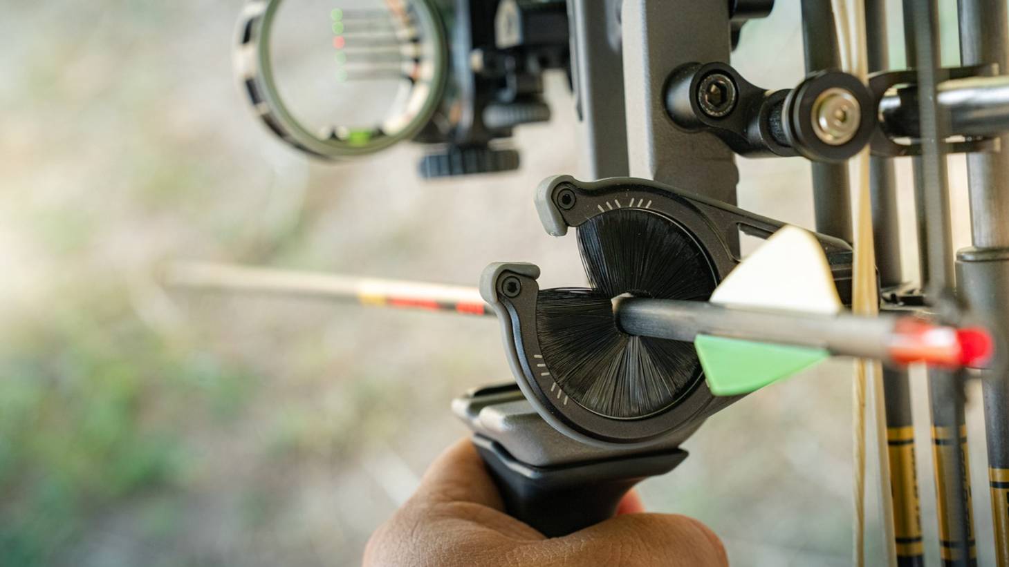 Close up image of the Whisker Biscuit Pro arrow rest from Trophy Ridge with an arrow through it on a compound bow.