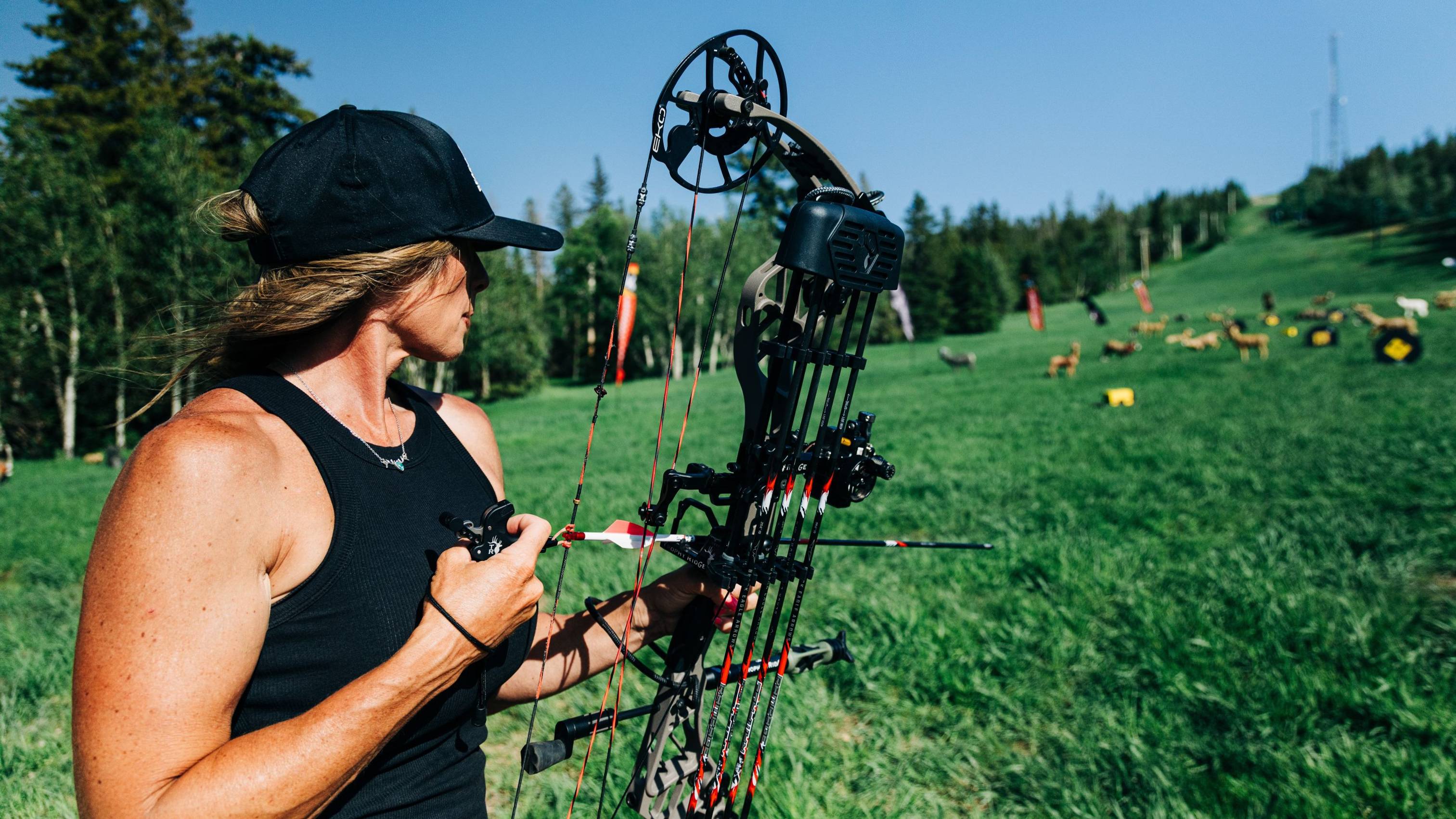 Woman using the 3 Finger Precise Pro bow release from Trophy Ridge for target practice.