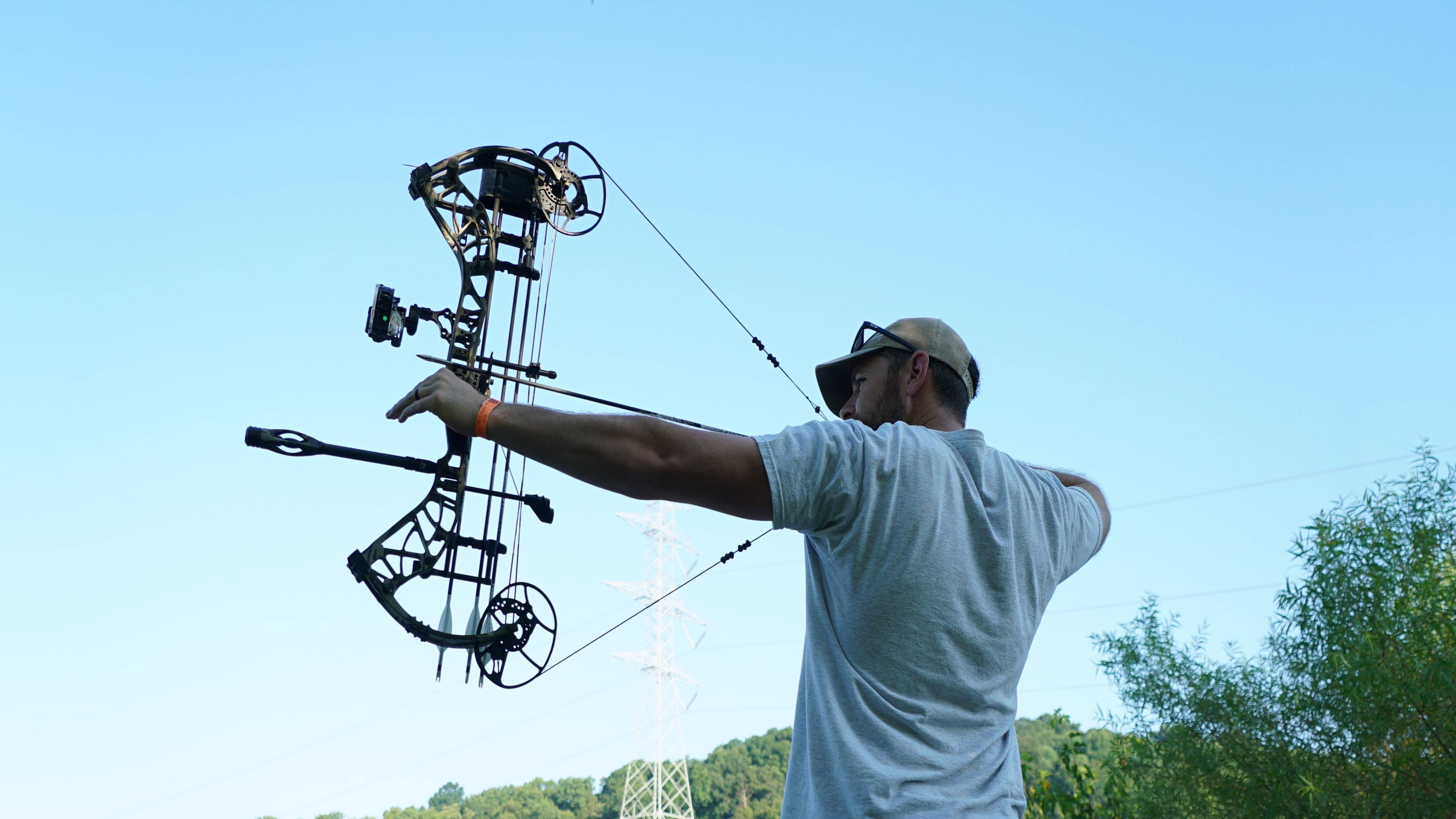 Man shooting a compound bow with a Seismic Stabilizer from Trophy Ridge attached