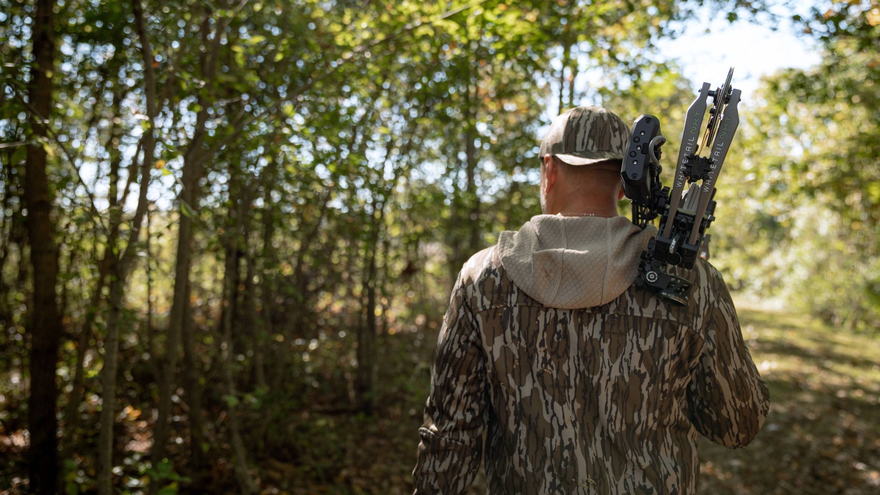 Man holding the Whitetail NXT compound bow from Bear Archery over his shoulder