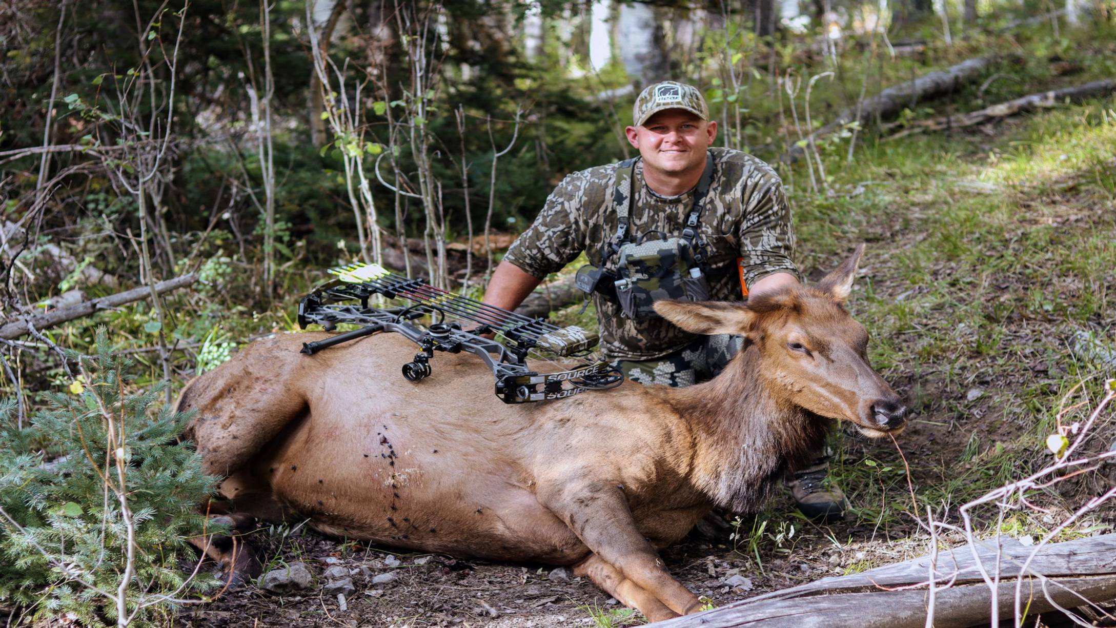Man with an animal he harvested with the Source compound bow from Bear Archery.