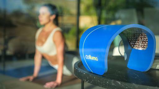 Women doing yoga in her living room with the Celluma SPORT on her table.