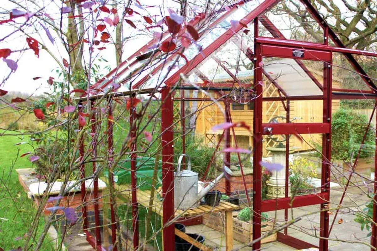 High Eave greenhouse set beautifully into garden scene