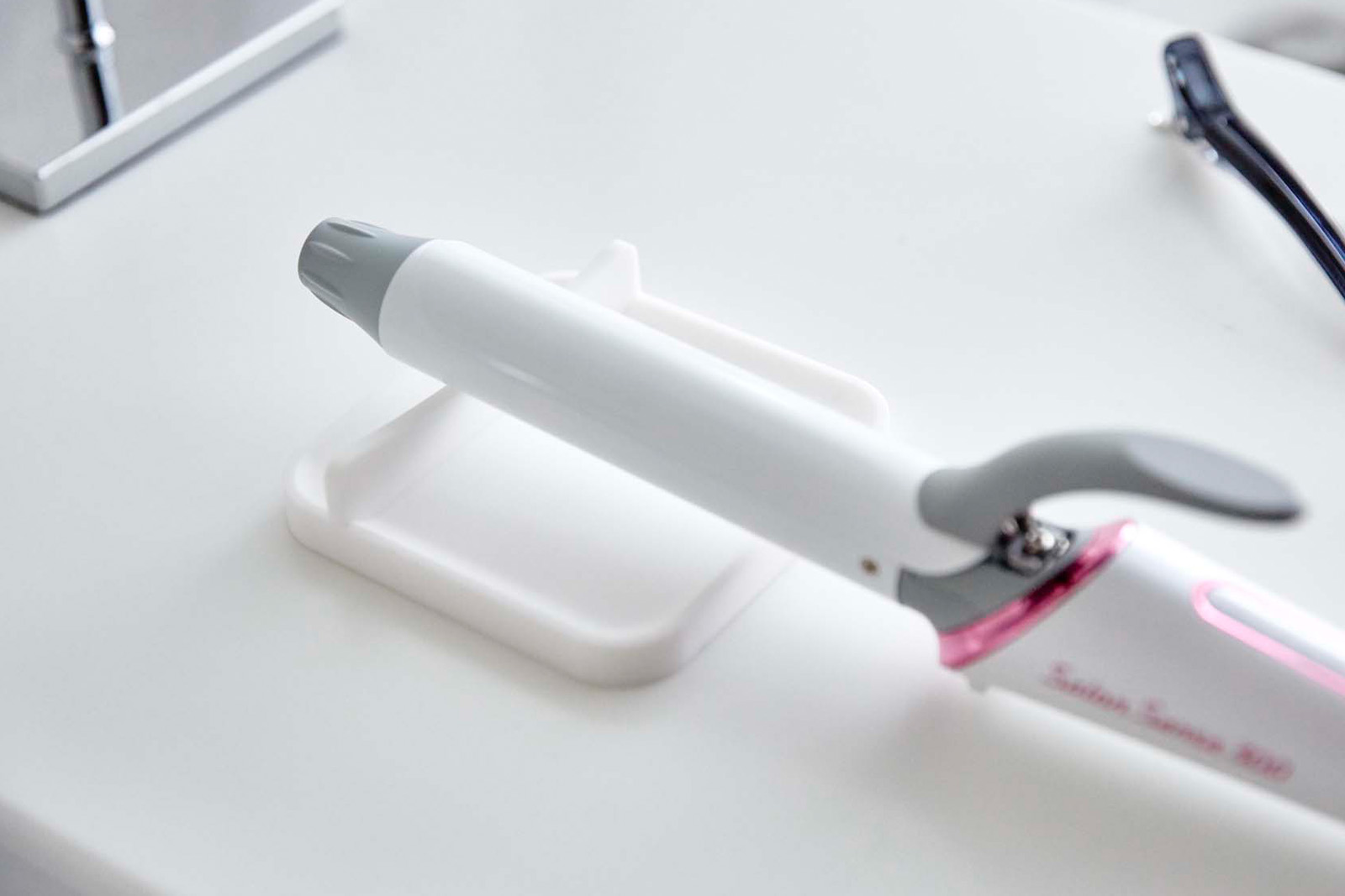 Haircare Appliance Rest holding curling wand by Yamazaki Home.