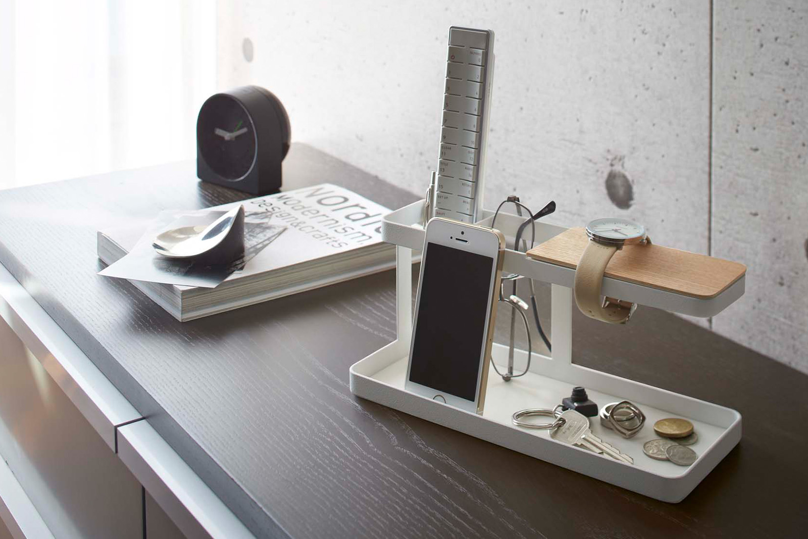 Yamazaki Home Desk Organizer holding a smart phone and a key board and a watch on the table. 