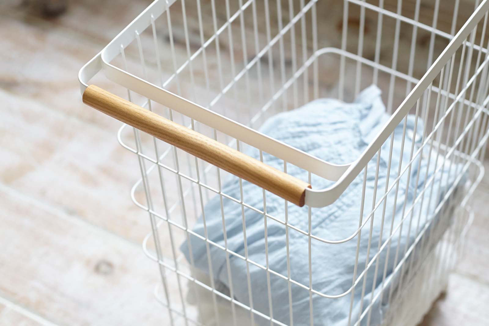 Close up view of Yamazaki Home Rolling Wire Basket holding towels. 