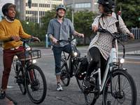Three friends laughing together while standing over their RadCity 5 Plus ebike models. 
