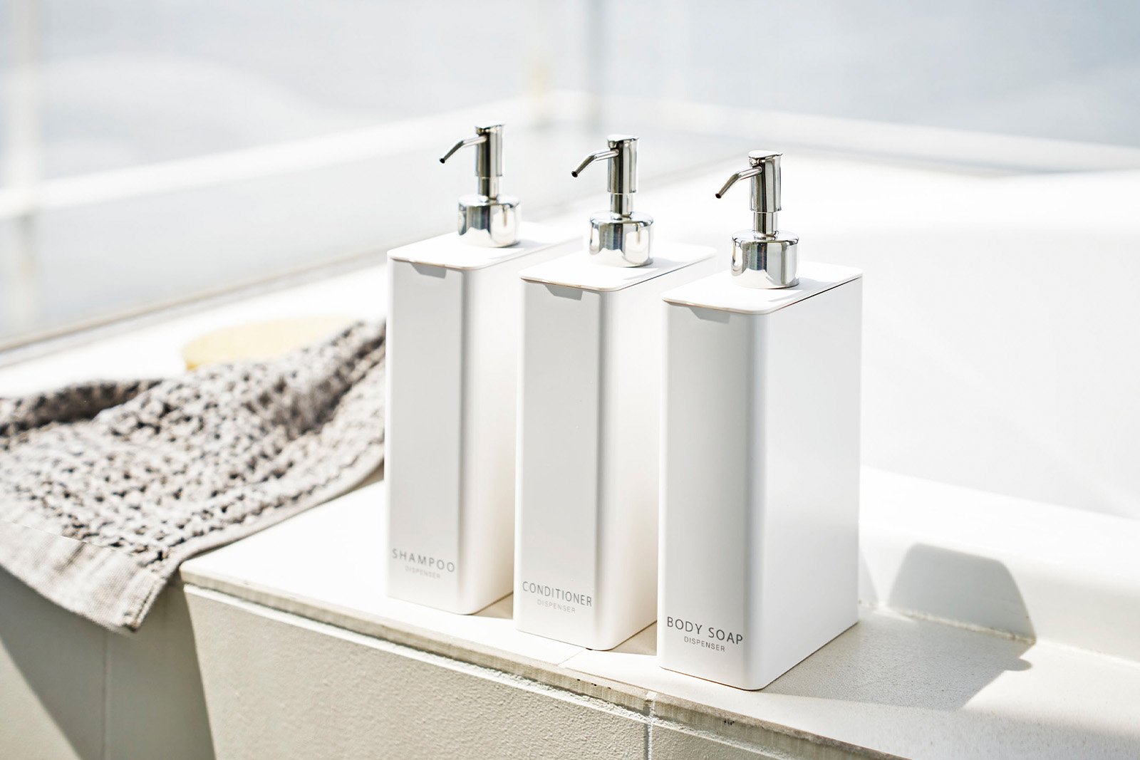 Yamazaki Home white square dispenser bundle on the bathtub. 