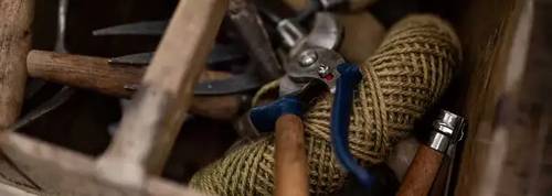 assortment of gardening tools in a wooden box