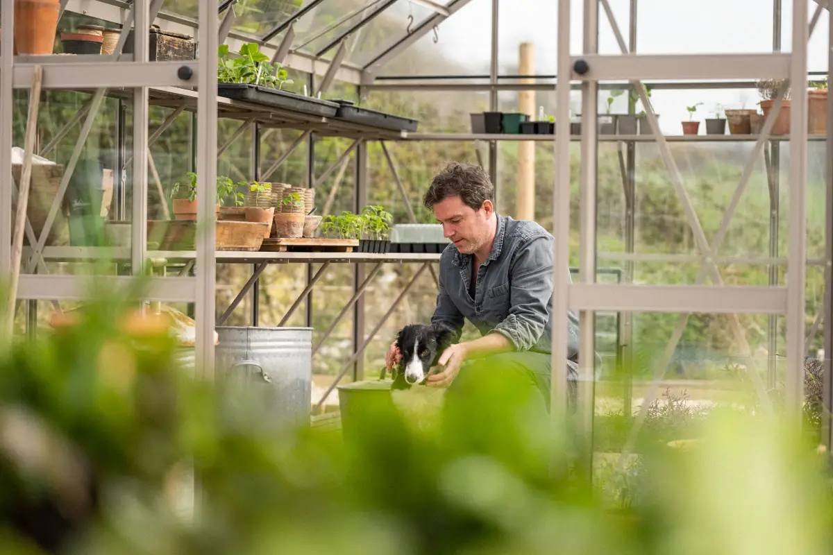 Gill Meller and his dog in their surrounded by plants