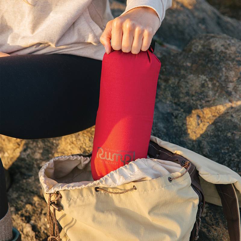 The NanoLoft® Flame synthetic down camping blanket packed up in its stuff sack