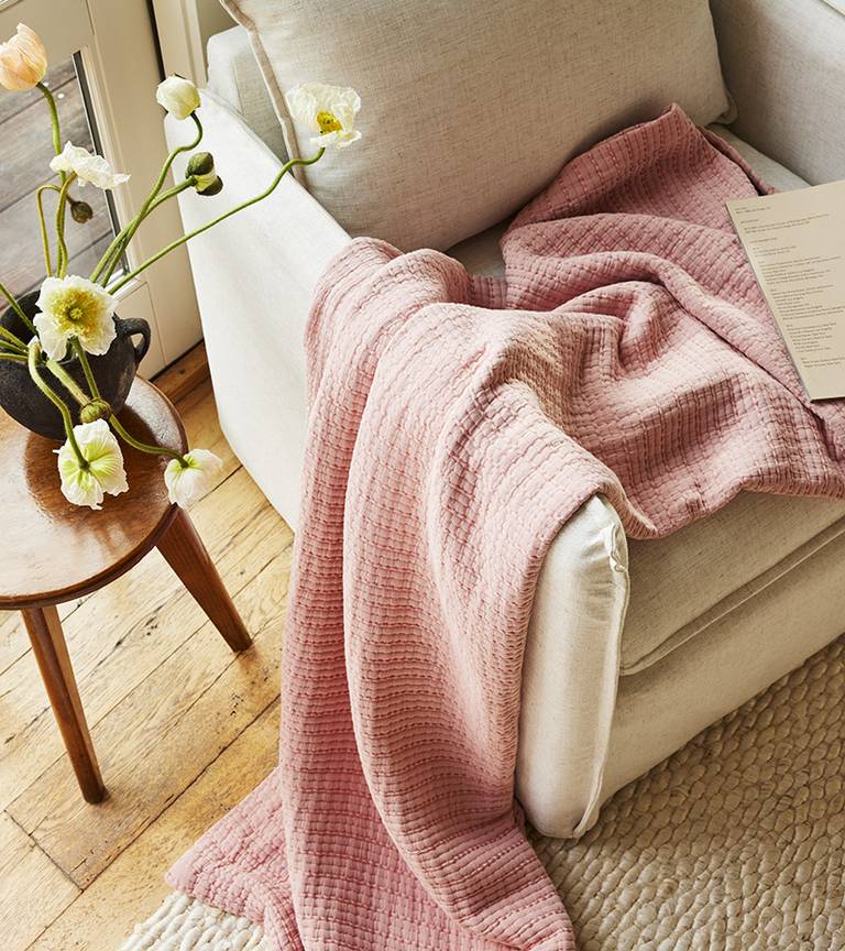 Brooklinen Lightweight Textured Throw Blanket in the color Dried Basil on a chair