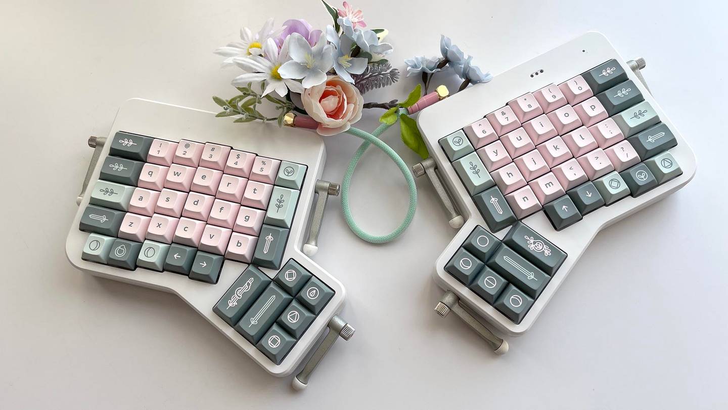 DSA Witch girl keycaps on white ErgoDox EZ ergonomic keyboard photographed with matching flowers and cable. 
