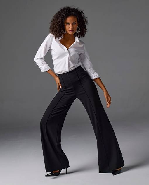 Model is wearing white button down and black trousers