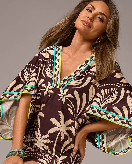 Models wearing a tropical print coverup