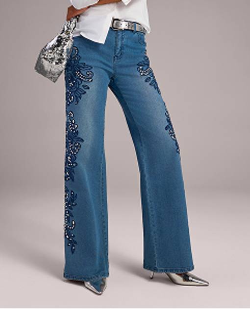 Models wearing blue jeans with embellishments. 