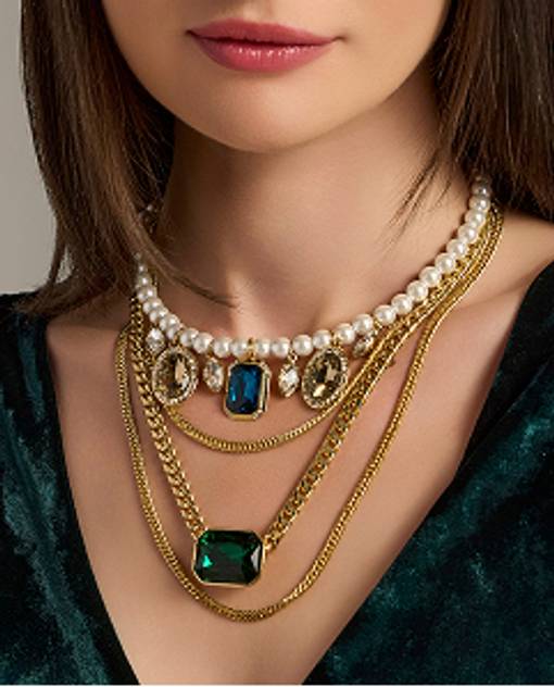 Models wearing a layered necklace with gemstones.