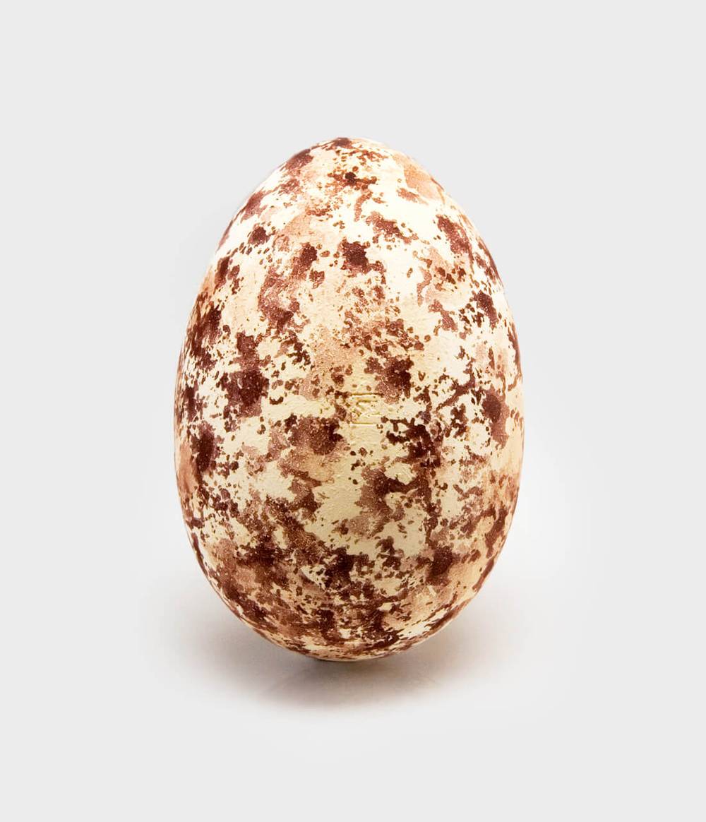 Breakable plaster gift packaging in an egg shape in brown and beige patterned colour