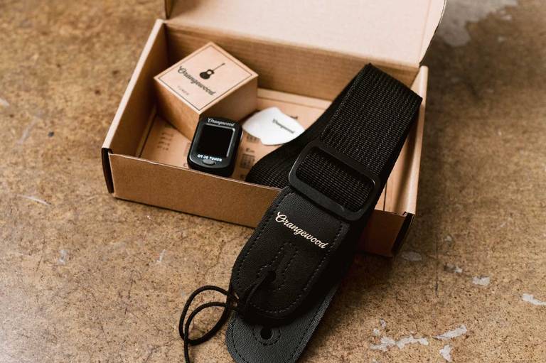 Ukulele accessory kit box with tuner, picks, and strap inside