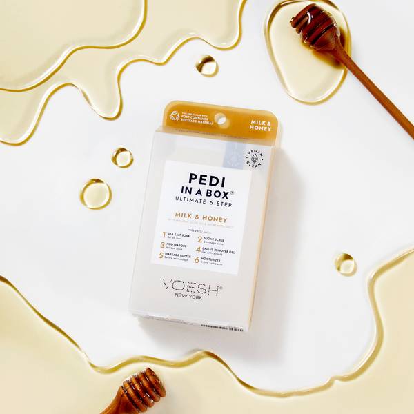 Pedi in a Box Ultimate 6 Step Milk & Honey Box sitting on honey and milk with yellow background
