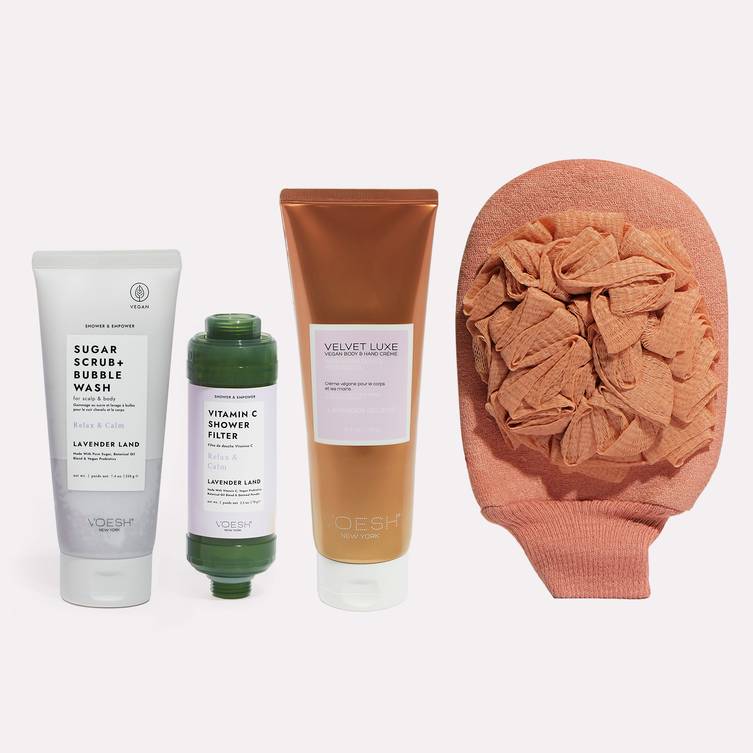 Image featuring VOESH Body Ritual Kit Relax that includes Vitamin C Shower Filter Lavender Land, Sugar Scrub + Bubble Wash Lavender Land, Vegan Hand & Body Crème 8.5 oz Lavender Relieve, and Exfoliating Loofah.