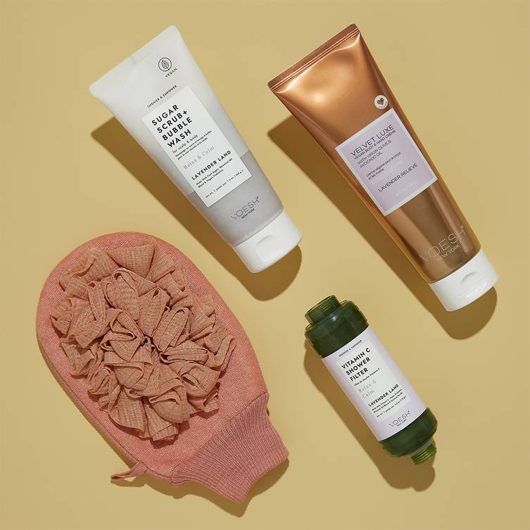 Image featuring VOESH Body Ritual Kit Relax that includes Vitamin C Shower Filter Lavender Land, Sugar Scrub + Bubble Wash Lavender Land, Vegan Hand & Body Crème 8.5 oz Lavender Relieve, and Exfoliating Loofah.
