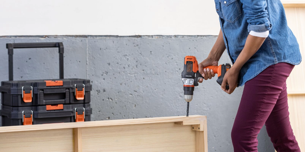 person using BLACK+DECKER drill