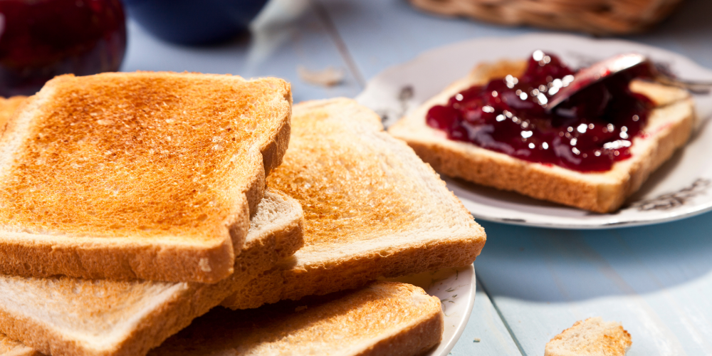 Toast and jam on a plate, having been made from a 4-slice stainless steel toaster